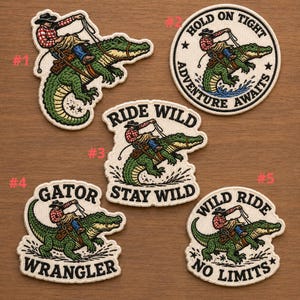 May include: Embroidered patches featuring a cowboy riding an alligator. The patches have various text, including "Hold on Tight," "Ride Wild," "Gator Wrangler," and "No Limits." The cowboy is wearing a red and black plaid shirt and a cowboy hat.