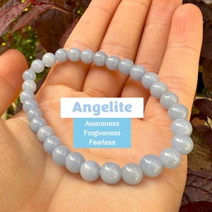 Könnte beinhalten: Ein hellblaues Angelit-Armband mit 8 mm Perlen. Das Armband besteht aus natürlichen Steinen und soll Bewusstsein, Vergebung und Furchtlosigkeit fördern.