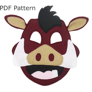 May include: A felt mask of a warthog with a burgundy face, tan ears, white tusks, and a black mane. The mask has a pink mouth with a white tooth showing.