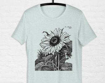 Könnte beinhalten: Ein hellblaues T-Shirt mit einer Schwarzweißillustration einer Sonnenblume mit dem Text "A.J.D.C. 1919" auf der Vorderseite.