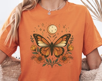 T-shirt floreale con farfalla boho, maglietta con fiori, maglietta con falena arancione, maglietta boho con stampa notturna, maglietta con farfalla celeste boho, maglietta da donna botanica