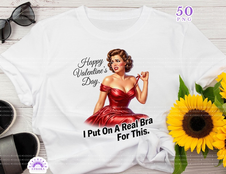 May include: White t-shirt with a retro illustration of a woman in a red dress, with the text "Happy Valentine's Day" and "I Put On A Real Bra For This.". The design includes a bouquet of sunflowers.