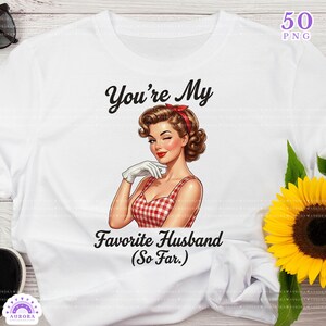 May include: White t-shirt featuring a retro illustration of a woman winking, wearing a red and white checkered dress. The text reads "You're My Favorite Husband (So Far.)". The design includes a red headband and white gloves.