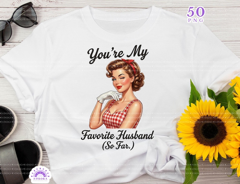 May include: White t-shirt featuring a retro illustration of a woman winking, wearing a red and white checkered dress. The text reads "You're My Favorite Husband (So Far.)". The design includes a red headband and white gloves.