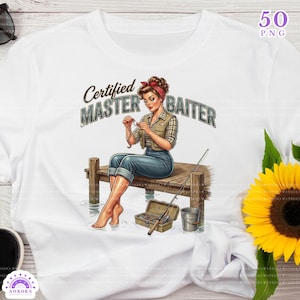 May include: White t-shirt featuring a graphic of a woman fishing, seated on a dock. The text "Certified Master Baiter" is above the woman. The image includes a fishing rod, tackle box, and a bucket. A pair of sunglasses and a sunflower are also visible.