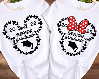 May include: Two white t-shirts featuring a black Mickey Mouse head outline made of small black Mickey Mouse ears. The shirts display "2023 Senior Graduate" with a graduation cap within the outline. One shirt has a red bow with white polka dots.