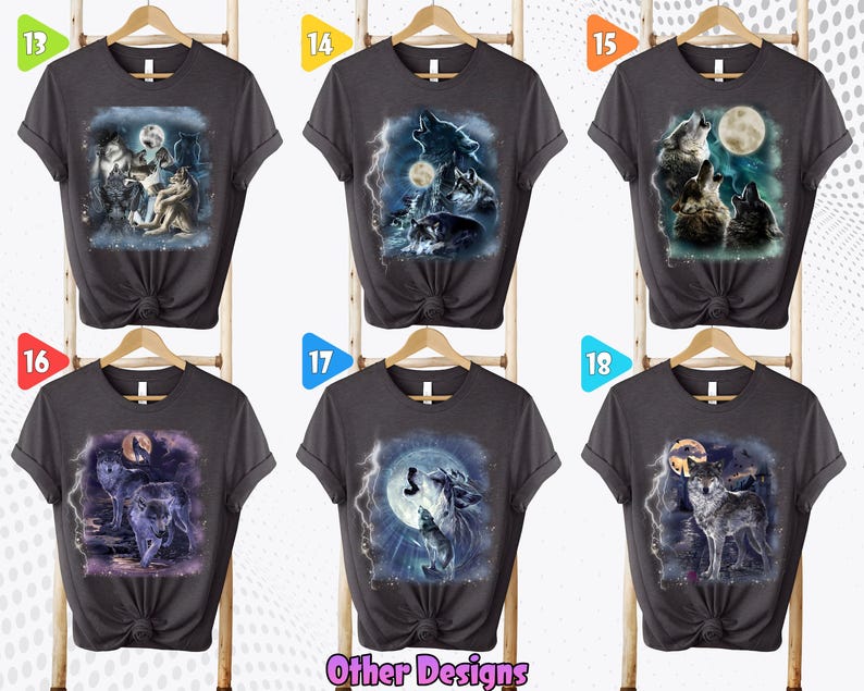 K&ouml;nnte beinhalten: Sechs graue T-Shirts mit verschiedenen Wolf-Designs, die darauf gedruckt sind. Die Designs zeigen W&ouml;lfe, die zum Mond heulen, wobei einige Designs Blitze und andere Naturelemente enthalten. Die Shirts werden alle auf Kleiderb&uuml;geln pr&auml;sentiert, wobei die Nummern 13, 14, 15, 16, 17 und 18 oben auf jedem Shirt sichtbar sind.