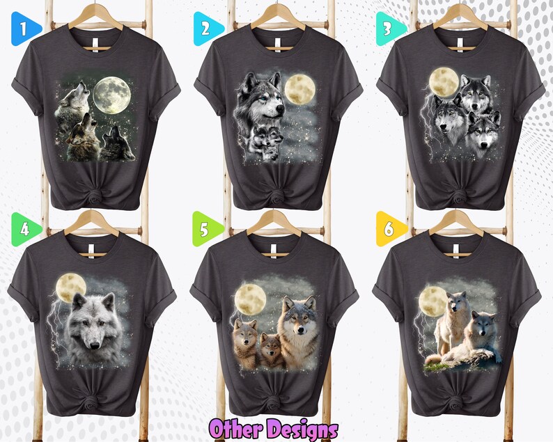K&ouml;nnte beinhalten: Sechs verschiedene graue T-Shirts mit Wolf- und Mondmotiven. Die Shirts werden auf Kleiderb&uuml;geln vor einem wei&szlig;en Hintergrund pr&auml;sentiert. Die Zahlen 1 bis 6 werden in bunten Kreisen &uuml;ber jedem Shirt angezeigt.