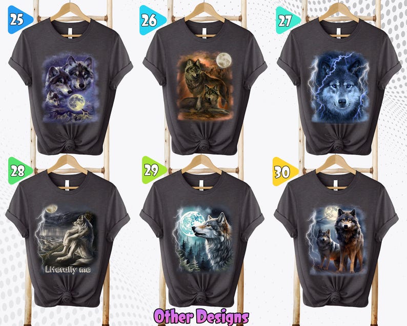 K&ouml;nnte beinhalten: Sechs graue T-Shirts mit verschiedenen Wolf-Designs. Die Designs beinhalten einen Wolf, der zum Mond heult, einen Wolf mit Blitz und einen Wolf mit einem blauen Leuchten. Die Shirts h&auml;ngen alle an Kleiderb&uuml;geln und haben einen wei&szlig;en Hintergrund.