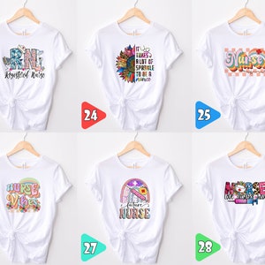 May include: Six white t-shirts with different designs featuring the word "Nurse" and related imagery. The designs include a rainbow, a sunflower, a stethoscope, and a syringe.