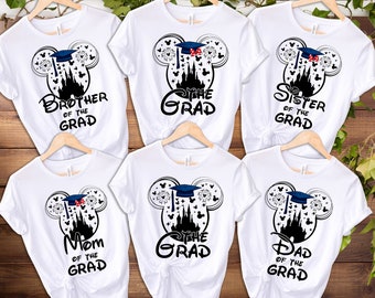 May include: Five white t-shirts featuring a black and white graphic of Mickey Mouse ears with a graduation cap. The shirts have text that reads "Brother of the Grad", "Mom of the Grad", "The Grad", "Sister of the Grad", and "Dad of the Grad".