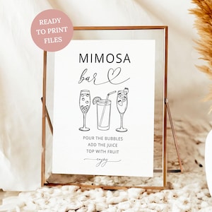 May include: A white rectangular sign in a copper frame featuring black text that reads MIMOSA bar, POUR THE BUBBLES, ADD THE JUICE, TOP WITH FRUIT, and enjoy. The sign includes line art illustrations of two champagne flutes and a juice glass.