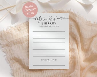 May include: A white rectangular card with black text that reads baby's first LIBRARY, CHOSEN FOR YOU BECAUSE, and GIVEN WITH LOVE BY, featuring eight horizontal lines for writing and a small heart icon between the words baby's and first.