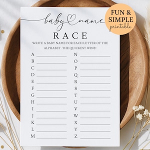 May include: A white baby name race game card with the text "baby name RACE". The card includes lines for each letter of the alphabet. A circular sticker reads "FUN & SIMPLE printable". The card is on a wooden plate.