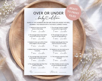 May include: A white paper game card titled Over or Under Baby Edition with black text listing twelve baby-related facts to guess. A circular pink badge in the top right corner reads Ready to Print Files. The card includes lines for name and total points.