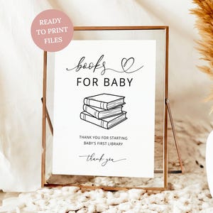 Peut inclure: Un panneau blanc encadré avec les mots "books FOR BABY" en écriture noire. En dessous du texte se trouve une pile de trois livres. Le panneau indique "THANK YOU FOR STARTING BABY'S FIRST LIBRARY" et "thank you".