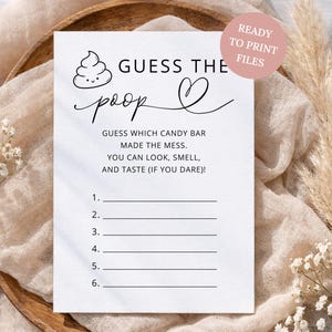 May include: A white rectangular game card featuring a black line drawing of a smiling poop emoji and the text GUESS THE poop with a heart symbol. Below, the text reads GUESS WHICH CANDY BAR MADE THE MESS. YOU CAN LOOK, SMELL, AND TASTE (IF YOU DARE)!