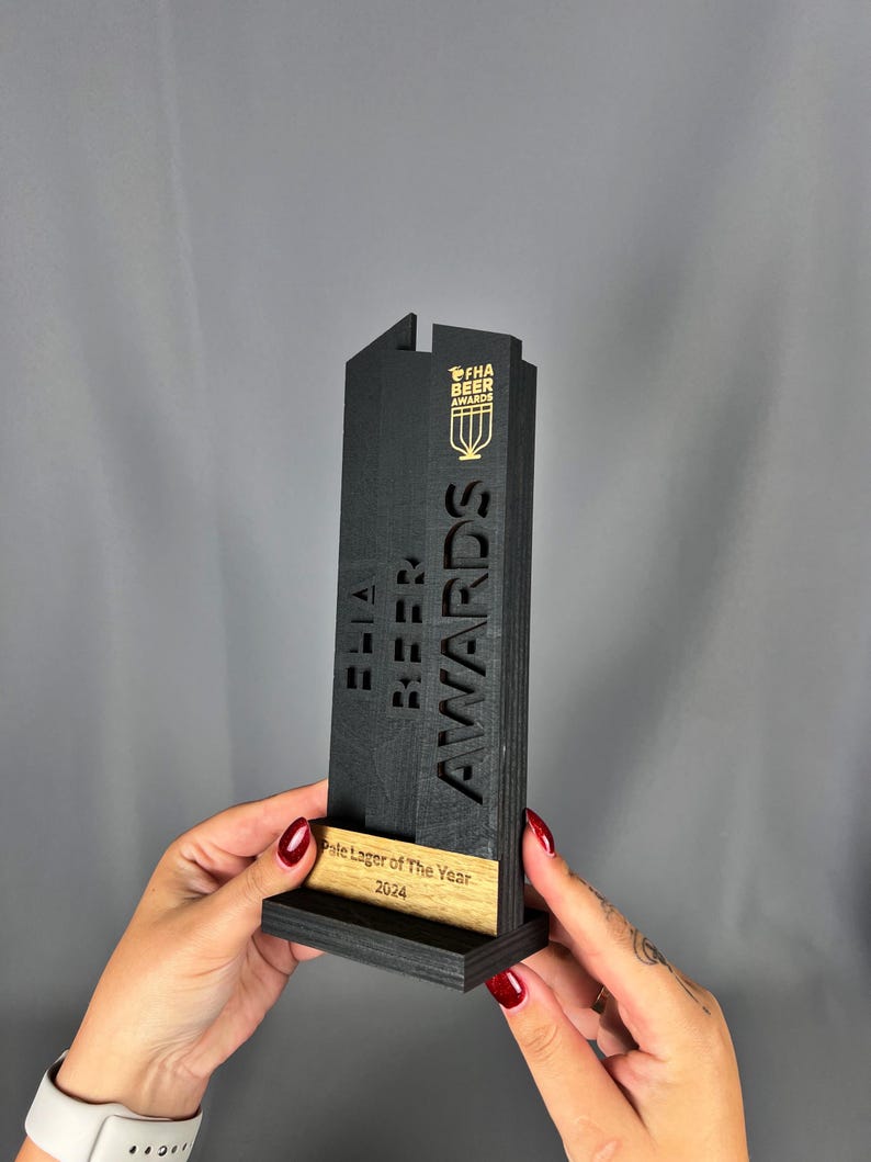 May include: Black wooden award with the text "FHA Beer Awards" and "Pale Lager of the Year 2024" on a wooden base.