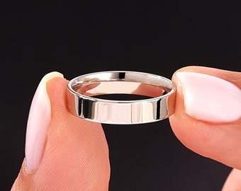 May include: A simple silver wedding band with a flat, polished surface.