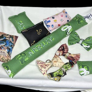 Peut inclure: Un ensemble de neuf jouets pour chat en tissu de couleur verte, noire et cr&egrave;me avec diff&eacute;rents motifs sur le th&egrave;me d'Harry Potter. Les jouets comprennent un long jouet vert avec les mots "Slytherin" imprim&eacute;s dessus, un jouet noir avec les mots "Slytherin" imprim&eacute;s dessus et un jouet cr&egrave;me avec les mots "Azakaban Prisoner" imprim&eacute;s dessus.