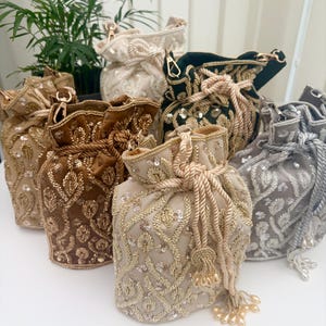 Peut inclure: Plusieurs sacs à cordon ornés, de couleurs or, marron, crème et argent. Les sacs présentent des broderies complexes, des paillettes et des perles. Chaque sac est doté d'une fermeture à cordon et d'un pompon.