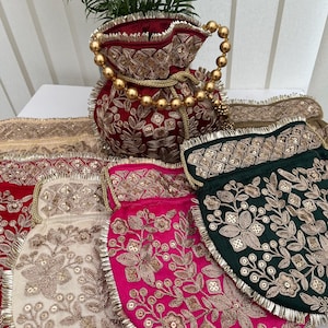 Può includere: Un assortimento di borse ricamate con coulisse in vari colori, tra cui rosso, rosa, crema e verde. Le borse presentano intricati motivi floreali dorati e manici con perline. Le borse sono realizzate in materiale simile al velluto e hanno un bordo con frange.