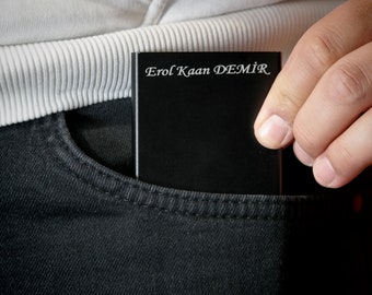 May include: A black rectangular case with the text "Erol Kaan DEMIR" engraved in white.
