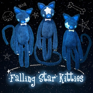 May include: Three plush blue cat dolls with white star and bow tie details. The dolls have long limbs and tails, set against a starry night backdrop with the text "Falling Star Kitties".