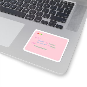 May include: A pink sticker on a laptop with the text "SELECT 'sequel' as Correct 'es cue el' as Wrong FROM Pronunciation". The sticker has a white border and is rectangular with rounded corners. The laptop is silver.