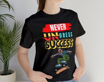 Puede incluir: Camiseta negra con un diseño gráfico que dice "Never Undress Success" con un esqueleto haciendo skateboard.