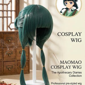 May include: A teal cosplay wig with bangs and two low pigtails secured with gold bands. The wig is displayed on a white stand. Text on the image reads "COSPLAY WIG" and "MAOMAO COSPLAY WIG".