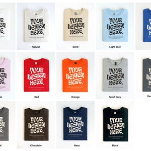 Pu&ograve; includere: Un mockup di 12 magliette di diversi colori con il testo "Your Design Here" stampato sul davanti. I colori sono bianco, naturale, sabbia, azzurro, blu reale, rosa chiaro, rosso, arancione, grigio sportivo, grigio scuro, antracite, cioccolato, blu navy e nero.
