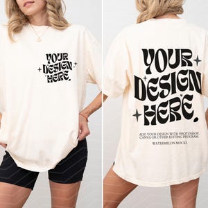 May include: An oversized white t-shirt with the text "YOUR + DESIGN + HERE" on the front and "YOUR + DESIGN + HERE" on the back. The text is in a retro font style. The t-shirt is being modelled by a person wearing black shorts.