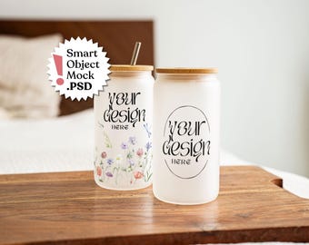 May include: Two frosted glass tumblers with bamboo lids and straws. The left tumbler features a colorful wildflower print and the text "YOUR DESIGN HERE". The right tumbler displays the text "YOUR DESIGN HERE" inside an oval frame. A badge reads "Smart Object Mock .PSD".