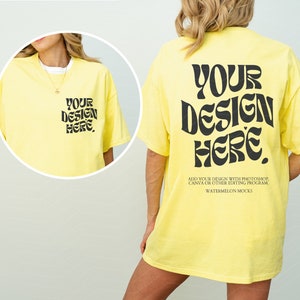 Könnte beinhalten: Ein gelbes T-Shirt mit dem Text "YOUR DESIGN HERE" in Schwarz auf Vorder- und Rückseite. Der Text ist in einem Retro-Schriftart-Stil.