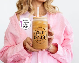 May include: A frosted glass tumbler with a bamboo lid and a clear straw, filled with a light brown beverage. The glass features a black oval graphic containing the text YOUR DESIGN HERE. A white circular badge reads Smart Object Mock .PSD.