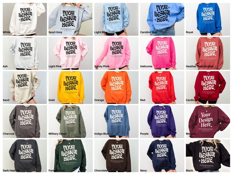 May include: A collection of 20 crewneck sweatshirts in various colours, including white, grey, light blue, Carolina blue, royal blue, ash, light pink, safety pink, heliconia, heather sport scarlet, sand, gold, orange, red, cardinal, charcoal, military green, indigo blue, purple, maroon, dark heather, forest green, chocolate, navy, and black. Each sweatshirt features the text "Your Design Here" in a bold, stylised font.
