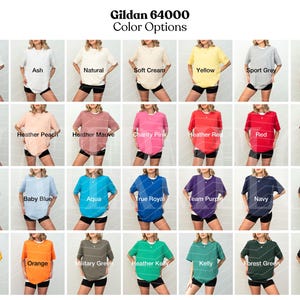 May include: A color chart showing 36 different Gildan 64000 t-shirt colors. The colors are arranged in four rows of nine colors each. The colors include white, ash, natural, soft cream, yellow, sport grey, dark heather, light pink, heather peach, heather mauve, charity pink, heather red, red, maroon, light blue, baby blue, aqua, true royal, team purple, navy, chocolate, gold, orange, military green, heather kelly, kelly, forest green, and black.