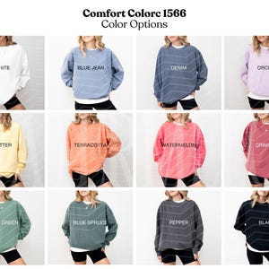 May include: A grid of twelve Comfort Colors 1566 sweatshirts in various solid colors including white, blue jean, denim, orchid, butter, terracotta, watermelon, crimson, light green, blue spruce, pepper, and black, each worn over black shorts.
