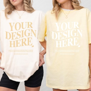 May include: Two short-sleeve crewneck t-shirts in ivory and banana yellow. Each shirt features the text YOUR DESIGN HERE in a large serif font, with smaller instructional text below regarding Photoshop or Canva editing software usage.