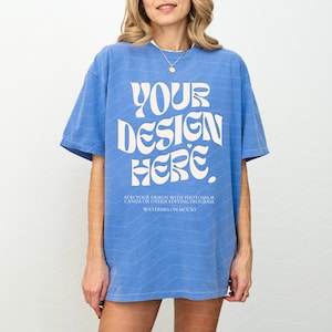 May include: A blue oversized t-shirt with a white graphic that says "YOUR DESIGN HERE". The text is in a retro font style. The shirt is made of a soft, comfortable material and is perfect for everyday wear.