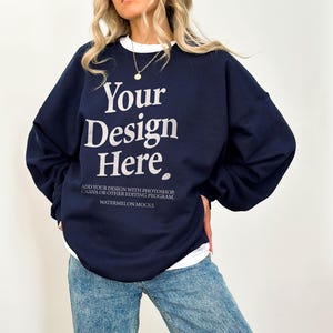 May include: A navy blue sweatshirt with the text "Your Design Here" in white. The text below the design reads "Add your design with Photoshop, Canva or other editing program. Watermelon Mocks."