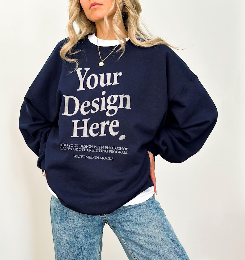May include: A navy blue sweatshirt with the text "Your Design Here" in white. The text below the design reads "Add your design with Photoshop, Canva or other editing program. Watermelon Mocks."