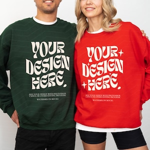 Könnte beinhalten: Ein dunkelgrünes Sweatshirt mit Rundhalsausschnitt und ein leuchtend rotes Sweatshirt mit Rundhalsausschnitt, beide mit dem weißen Text "YOUR DESIGN HERE" in wellenförmiger Schrift sowie Anweisungen zu Bearbeitungsprogrammen und dem Markennamen Watermelon Mocks.
