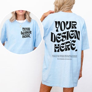 May include: A light blue oversized t-shirt with the text "YOUR DESIGN HERE" in a retro font on the back. The text "ADD YOUR DESIGN WITH PHOTOSHOP, CANVA OR OTHER EDITING PROGRAM WATERMELON MOCKS" is printed below the design.