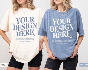 May include: Two short-sleeve crewneck t-shirts, one ivory and one blue jean, each featuring the text "YOUR DESIGN HERE" in large letters, with smaller text below reading "ADD YOUR DESIGN WITH PHOTOSHOP, CANVA OR OTHER EDITING PROGRAM. WATERMELON MOCKS."
