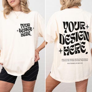 以下が含まれることがあります： オフホワイトの半袖Tシャツで、左胸と背面に黒い文字がプリントされています。文字は波打つフォントで「YOUR DESIGN HERE」と書かれ、星のアクセントがあります。追加のテキストには編集手順が記載されています。