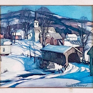 May include: A framed winter landscape painting depicts a snow-covered village with a covered bridge, church, and houses. The artwork features a blue sky, snow-covered hills, and leafless trees. The artist's signature is visible in the lower right corner.