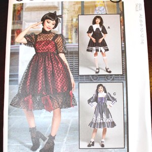 May include: McCall's costume pattern featuring three different dress designs. The main image showcases a red and black polka dot dress with a ruffled hem. The pattern includes sizes A5 (6-8-10-12-14). Designed and printed in the USA.