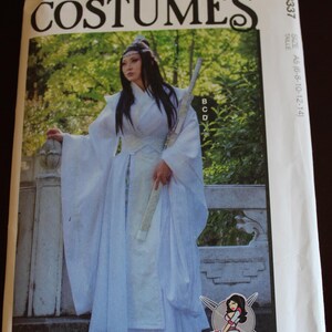 May include: McCall's Costumes pattern envelope featuring a person in a white costume with a sword. The envelope has the text "COSTUMES" and "M8337". The image is set against a backdrop of greenery.